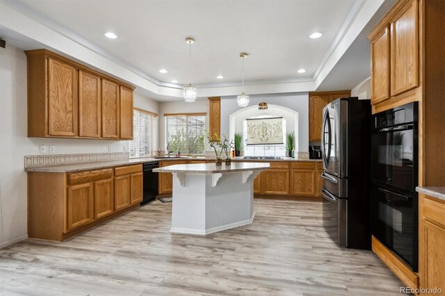 5293 Malaya St, Denver, CO 80249 - kitchen featuring black appliances, brown cabinets, a kitchen breakfast bar, and light wood finished floors