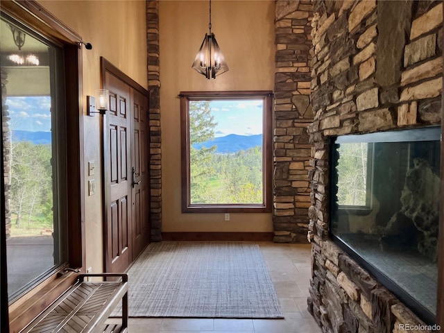 foyer with a healthy amount of sunlight, a chandelier, and light tile floors