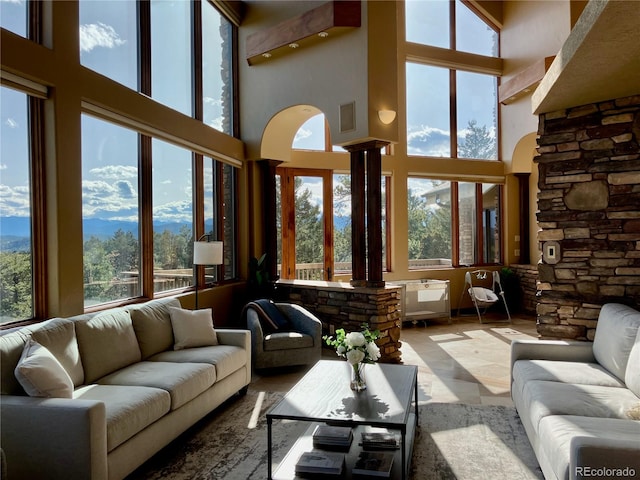 living room featuring a high ceiling and decorative columns