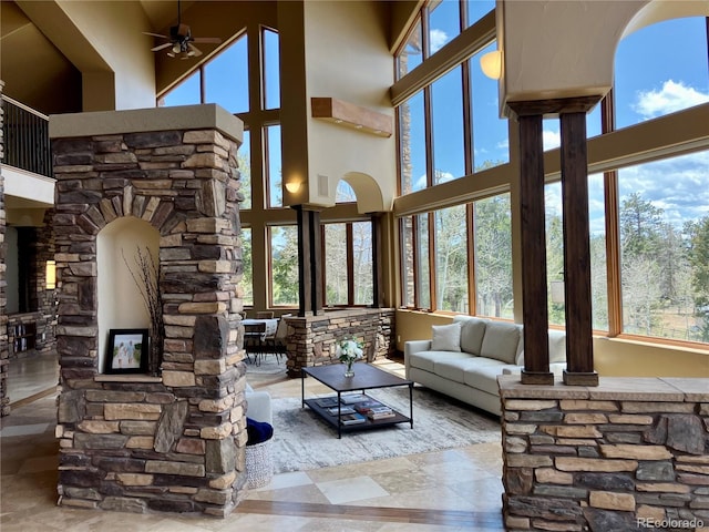 living room featuring tile flooring, ceiling fan, and a high ceiling