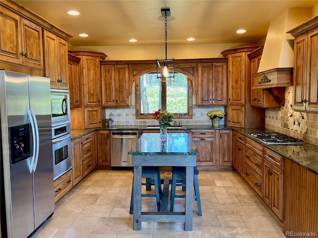 kitchen featuring dark stone counters, a kitchen island, stainless steel appliances, backsplash, and premium range hood