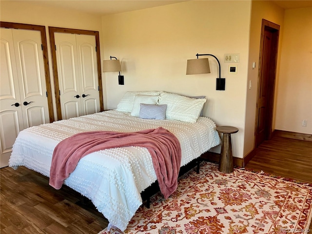 bedroom with hardwood / wood-style flooring and multiple closets