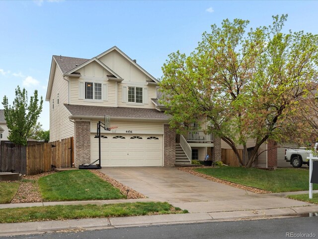4436 Windmill Dr, Brighton, CO 80601 - view of front of home with a garage, driveway, brick siding, board and batten siding, and stairs