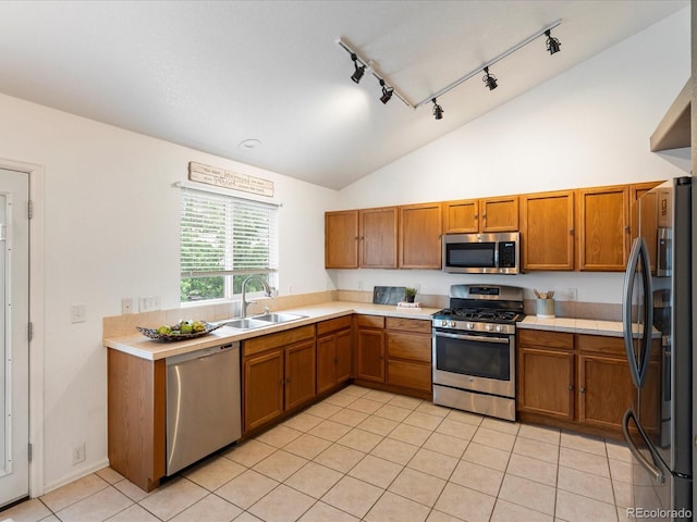 4436 Windmill Dr, Brighton, CO 80601 - kitchen featuring appliances with stainless steel finishes, brown cabinets, light tile patterned flooring, light countertops, and rail lighting