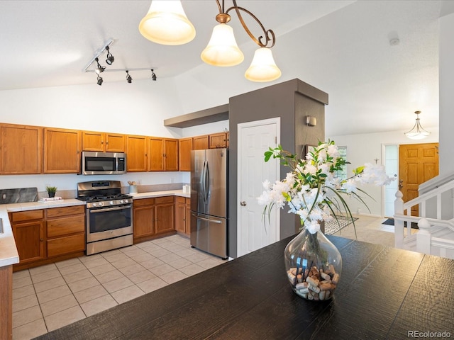 4436 Windmill Dr, Brighton, CO 80601 - kitchen with stainless steel appliances, brown cabinets, light countertops, light tile patterned floors, and high vaulted ceiling