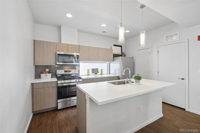 1711 Hooker St Unit 2, Denver, CO 80204 - kitchen with appliances with stainless steel finishes, an island with sink, light countertops, dark wood-type flooring, and backsplash