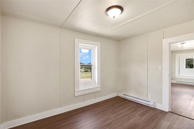 unfurnished room with dark hardwood / wood-style flooring and a baseboard heating unit