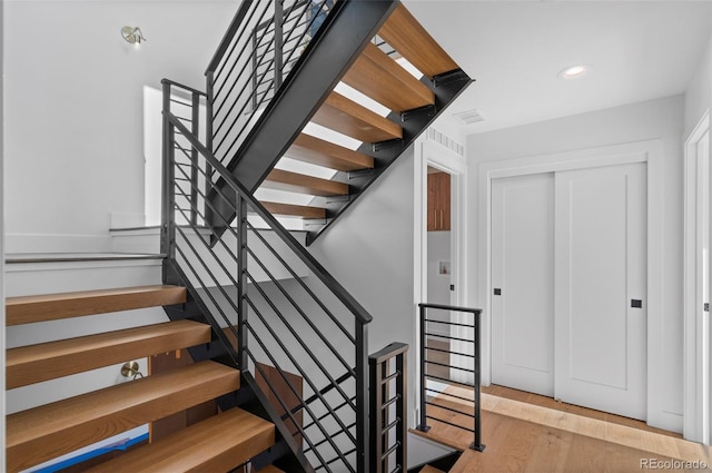 stairway with hardwood / wood-style flooring