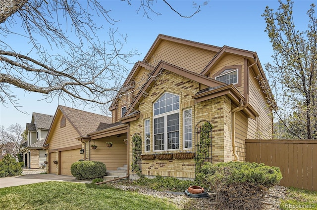 view of front facade with a front lawn, fence, brick siding, an attached garage, and driveway