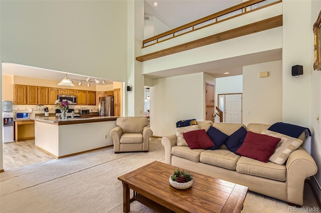 living room featuring recessed lighting, a high ceiling, and light carpet
