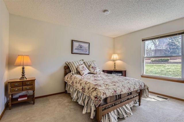 bedroom with visible vents, a textured ceiling, baseboards, and light carpet