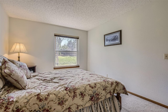 bedroom with baseboards, carpet, and a textured ceiling