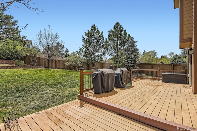 wooden deck with a fenced backyard and a lawn