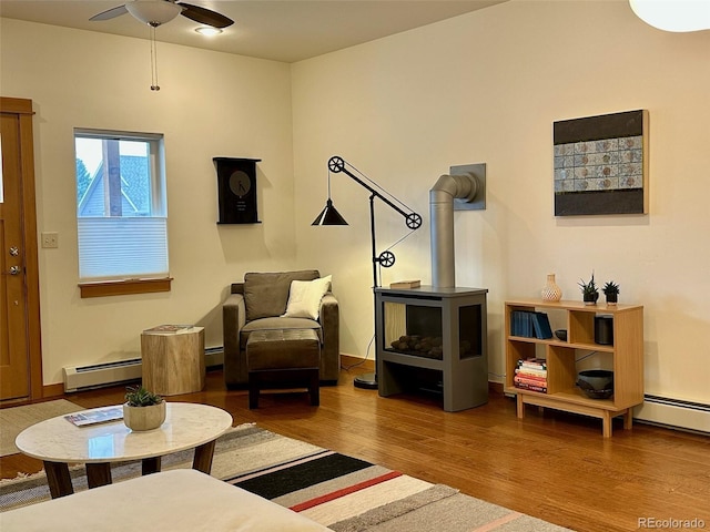 26 S Trailside Cir Unit A, Salida, CO 81201 - living room with a baseboard heating unit, wood finished floors, a wood stove, and ceiling fan