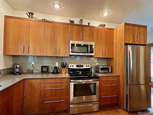 26 S Trailside Cir Unit A, Salida, CO 81201 - kitchen featuring appliances with stainless steel finishes, brown cabinetry, and backsplash