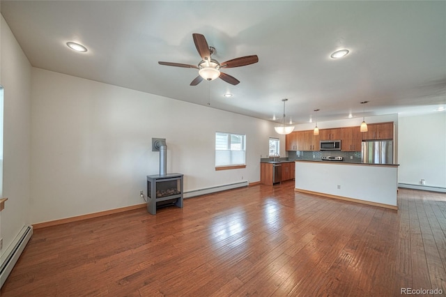 26 S Trailside Cir Unit A, Salida, CO 81201 - unfurnished living room featuring a baseboard heating unit, baseboard heating, a wood stove, ceiling fan, and recessed lighting