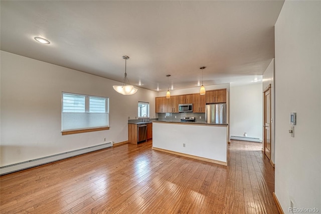 26 S Trailside Cir Unit A, Salida, CO 81201 - kitchen with stainless steel appliances, brown cabinetry, a baseboard radiator, and backsplash