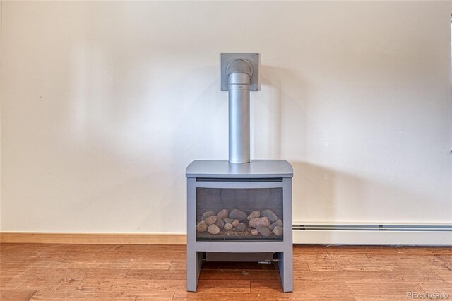 26 S Trailside Cir Unit A, Salida, CO 81201 - detailed view of a wood stove, a baseboard heating unit, and wood finished floors