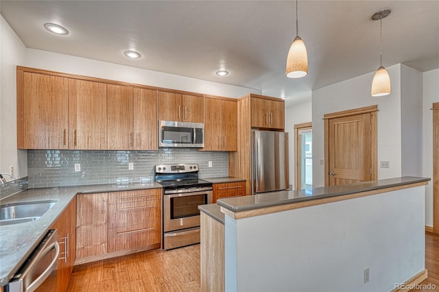 26 S Trailside Cir Unit A, Salida, CO 81201 - kitchen featuring stainless steel appliances, decorative backsplash, light wood-style floors, hanging light fixtures, and brown cabinets