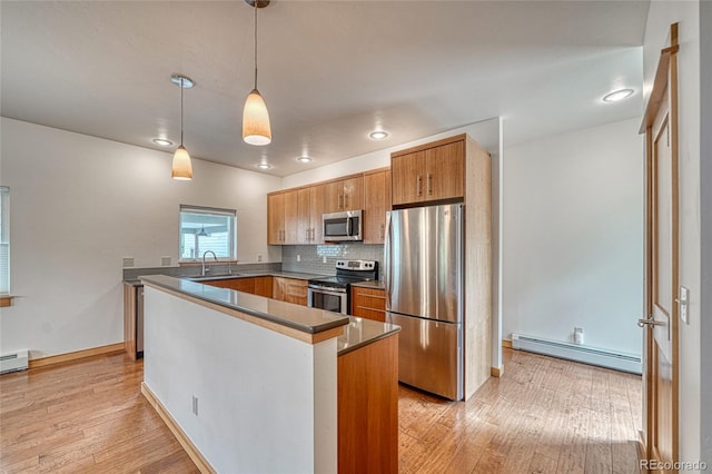 26 S Trailside Cir Unit A, Salida, CO 81201 - kitchen with a baseboard radiator, stainless steel appliances, light wood-style flooring, decorative backsplash, and decorative light fixtures
