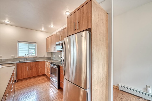 26 S Trailside Cir Unit A, Salida, CO 81201 - kitchen featuring appliances with stainless steel finishes, baseboard heating, light wood-style flooring, decorative backsplash, and recessed lighting