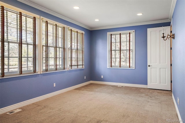 spare room featuring visible vents, baseboards, ornamental molding, and carpet flooring