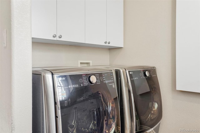 washroom with cabinet space and washing machine and clothes dryer