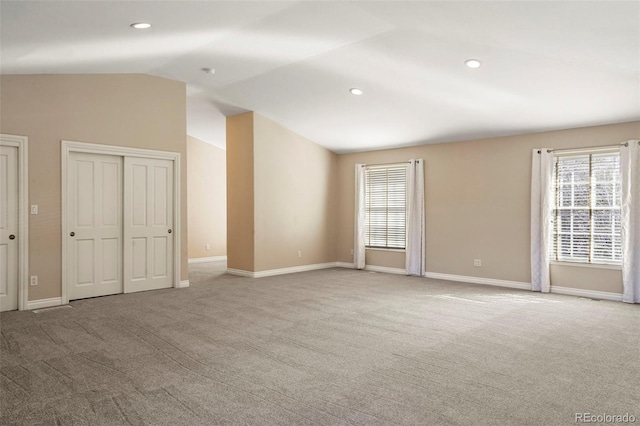 carpeted spare room featuring vaulted ceiling, plenty of natural light, recessed lighting, and baseboards