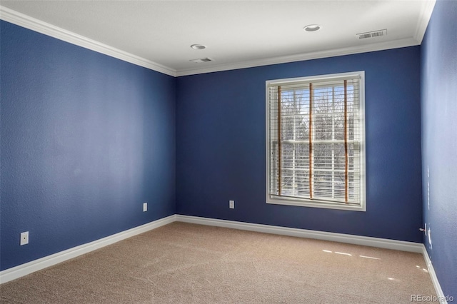 spare room featuring carpet flooring, crown molding, and visible vents