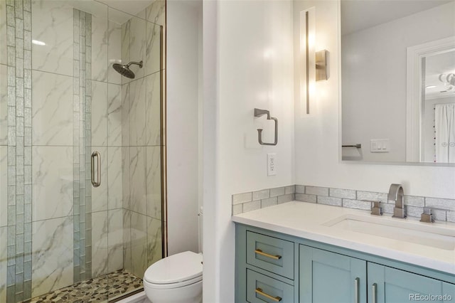 bathroom with toilet, a stall shower, and vanity