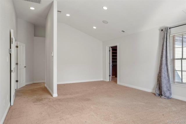 spare room with a wealth of natural light, recessed lighting, baseboards, and lofted ceiling