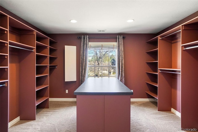 walk in closet with visible vents and light colored carpet