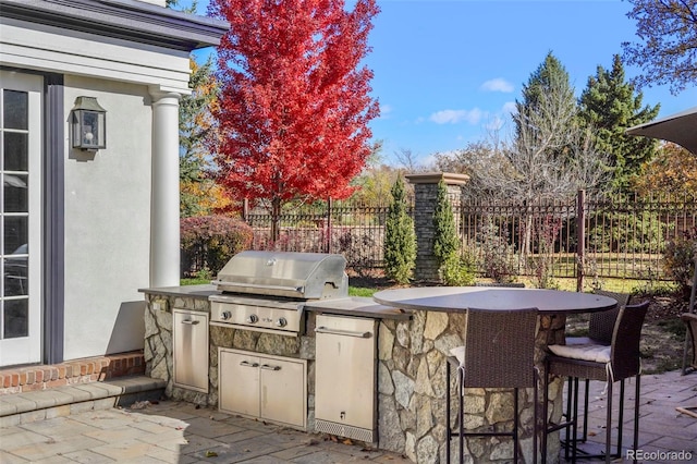 view of patio / terrace with area for grilling, fence, and an outdoor kitchen