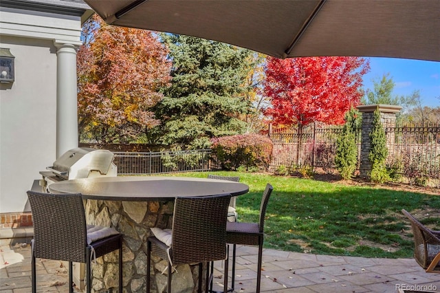 view of patio featuring exterior kitchen, a fenced backyard, and a grill