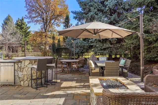 view of patio / terrace with outdoor dry bar, outdoor dining space, and fence