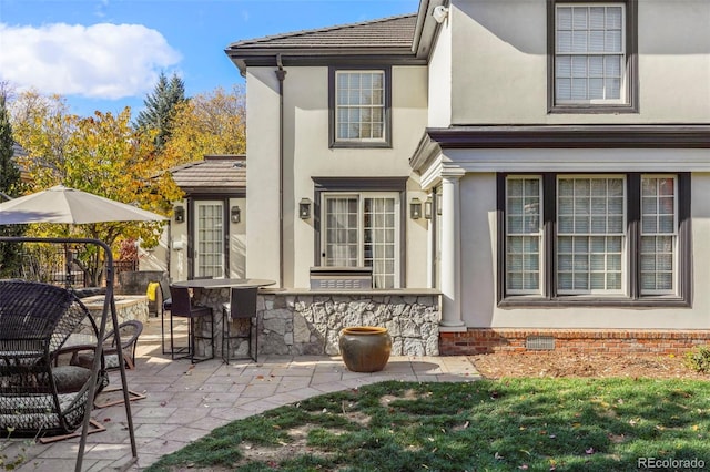 exterior space with crawl space, stucco siding, and a patio