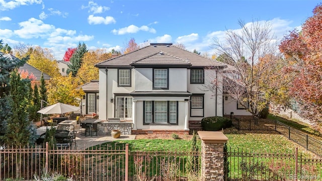 exterior space with stucco siding, a lawn, a fenced backyard, and a patio area