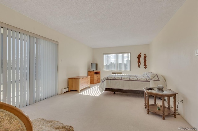 carpeted bedroom featuring a baseboard radiator and a textured ceiling