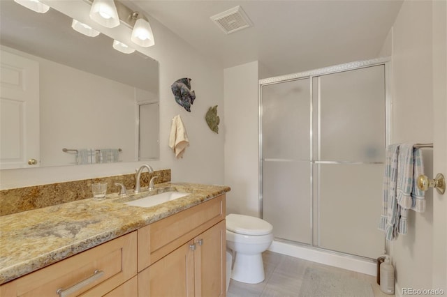 bathroom with tile patterned floors, vanity, toilet, and an enclosed shower