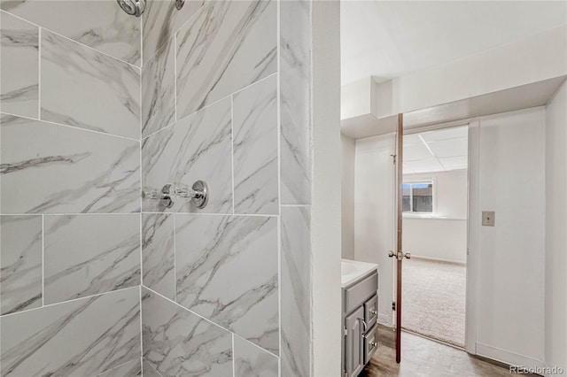 bathroom featuring tiled shower and vanity