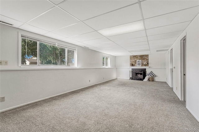 unfurnished living room with carpet floors and a drop ceiling