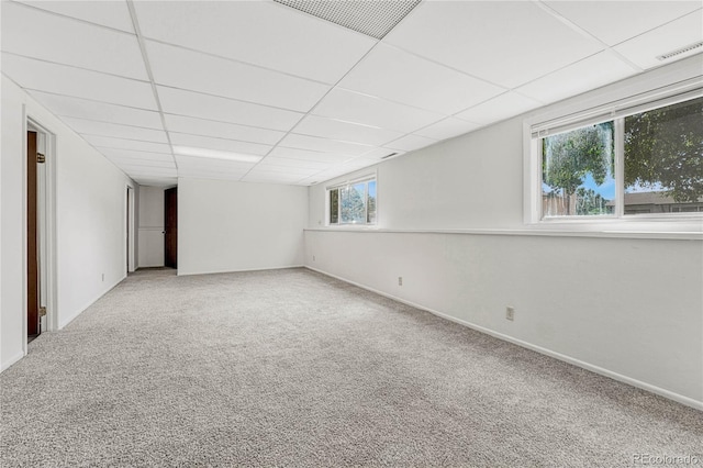 carpeted spare room featuring a paneled ceiling