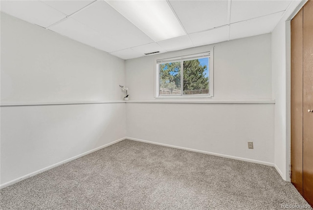 basement with a drop ceiling and carpet floors