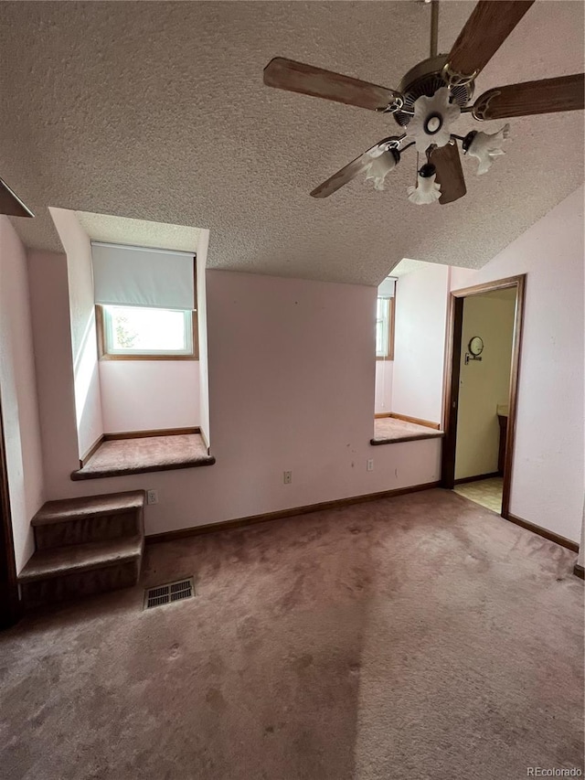 bonus room with a textured ceiling, carpet floors, ceiling fan, and lofted ceiling