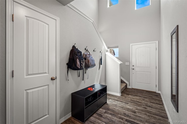 7568 Benecia Dr, Fountain, CO 80817 - mudroom with dark wood finished floors, a towering ceiling, and baseboards
