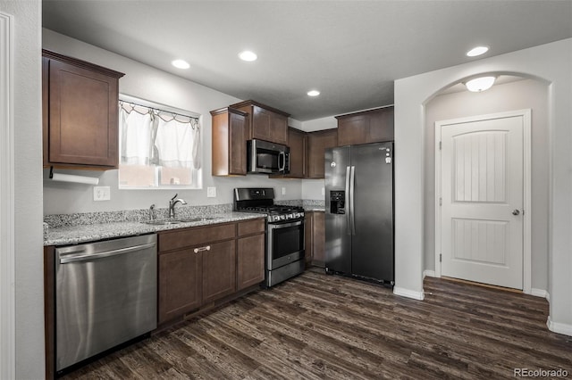 7568 Benecia Dr, Fountain, CO 80817 - kitchen featuring appliances with stainless steel finishes, dark wood-style flooring, a sink, recessed lighting, and light stone countertops