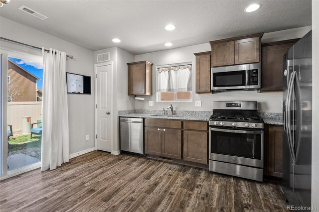 7568 Benecia Dr, Fountain, CO 80817 - kitchen featuring stainless steel appliances, dark wood finished floors, light stone countertops, a sink, and recessed lighting