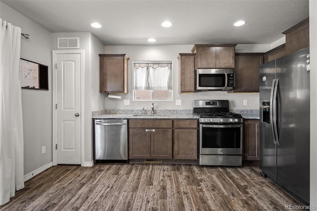 7568 Benecia Dr, Fountain, CO 80817 - kitchen with stainless steel appliances, a sink, dark wood-type flooring, light stone counters, and recessed lighting