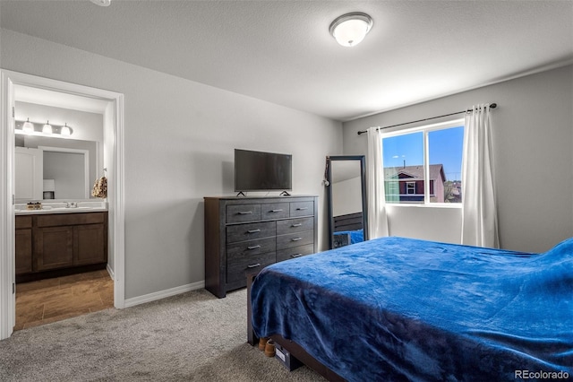 7568 Benecia Dr, Fountain, CO 80817 - carpeted bedroom with a sink, connected bathroom, and baseboards