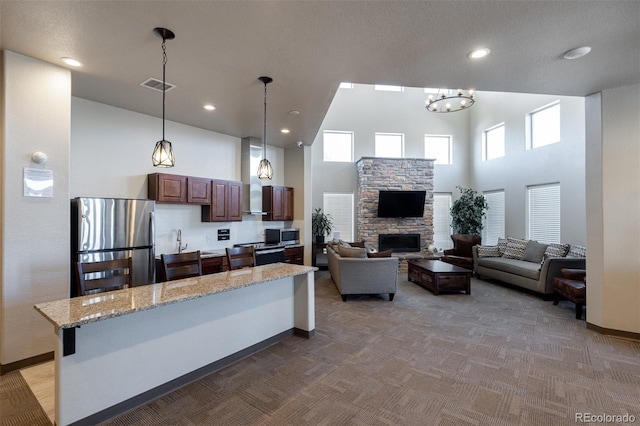 7568 Benecia Dr, Fountain, CO 80817 - kitchen featuring appliances with stainless steel finishes, a high ceiling, carpet, baseboards, and healthy amount of natural light